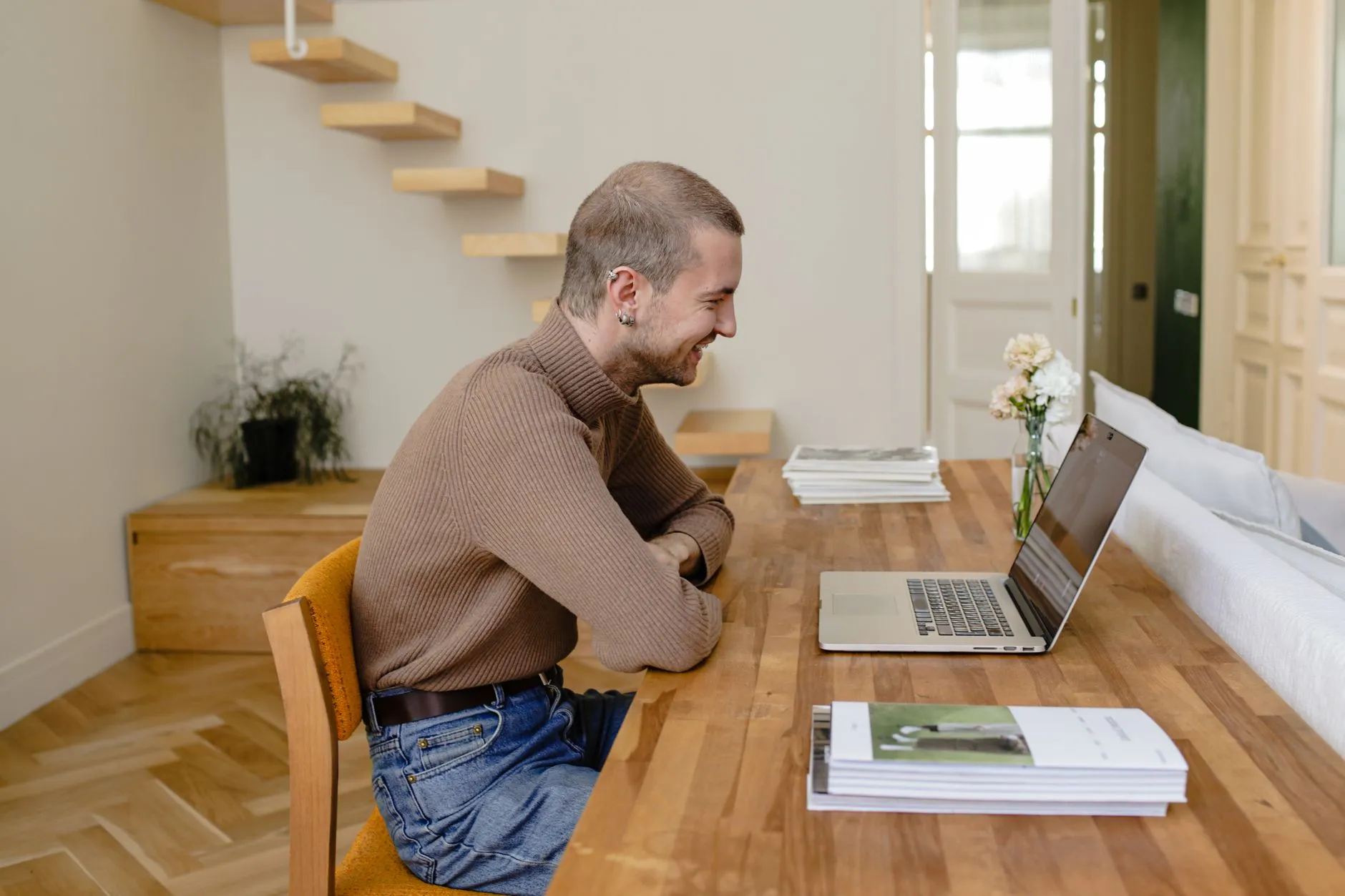 A smiling man on a video call at his laptop